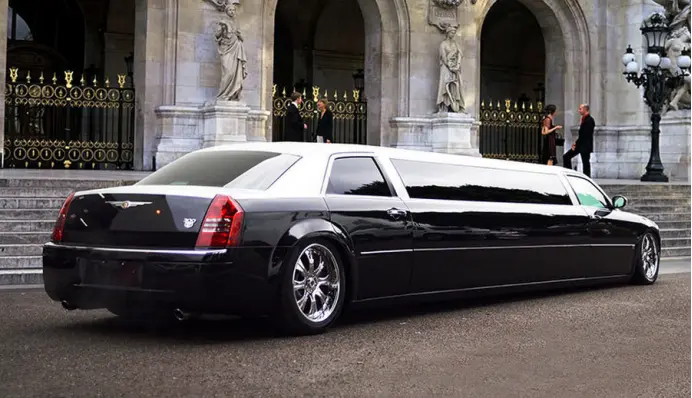 a black and white limousine parked in front of a building