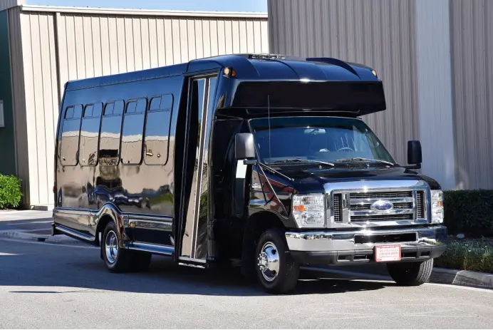 a black bus parked in front of a building