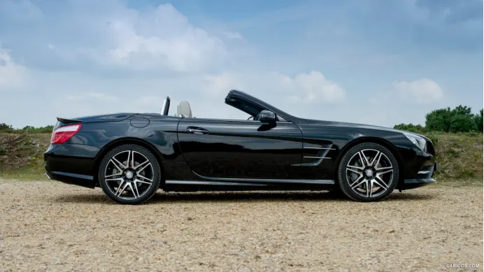 a black sports car parked on a gravel road