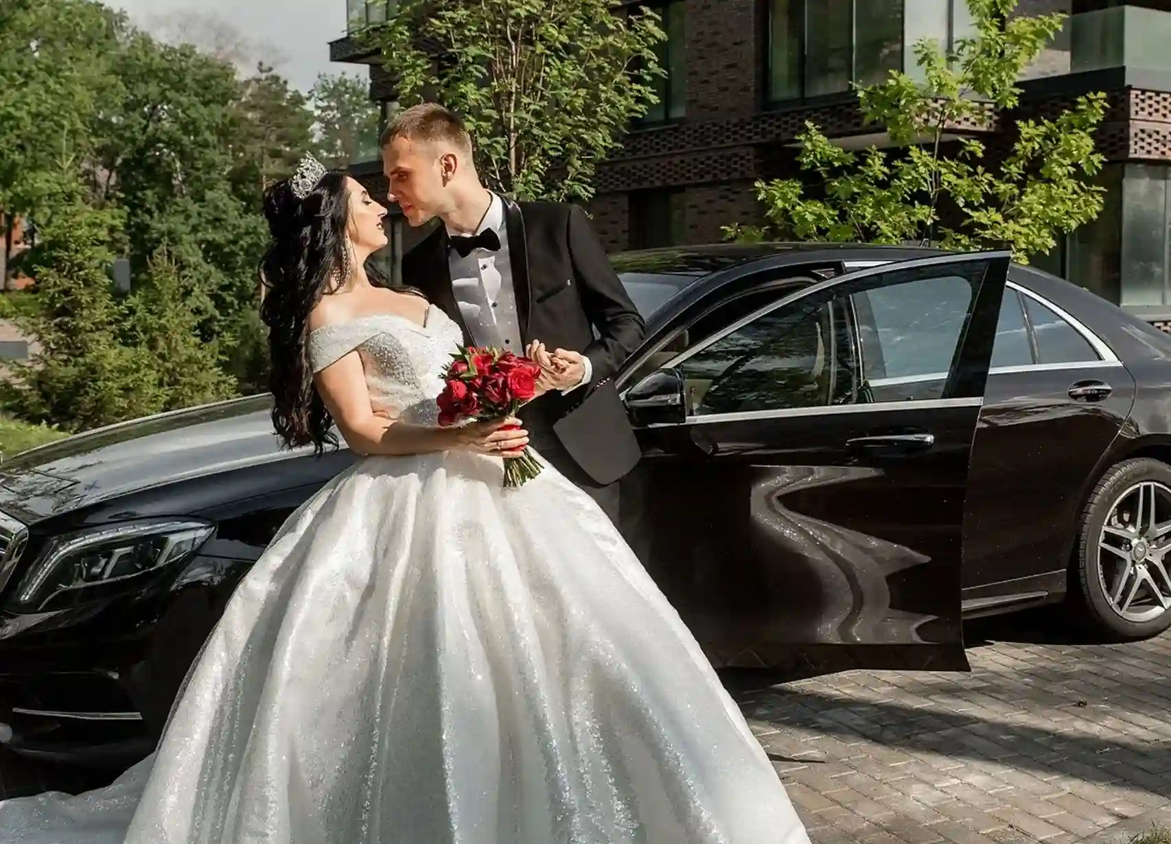 Wedding Transportation a bride and groom standing in front of a car