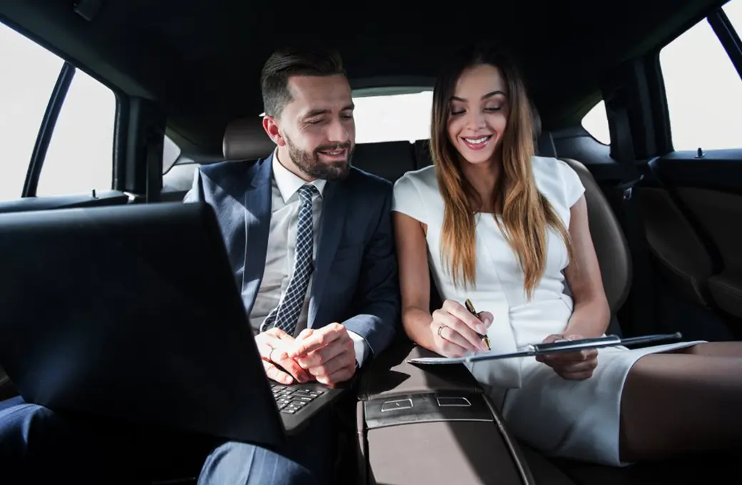 a man and woman sitting of car backsit limo service in New York.