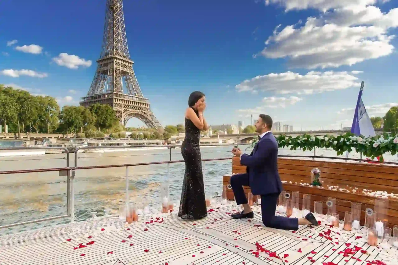 a man and woman sitting on a bench in front of the eiffel tower