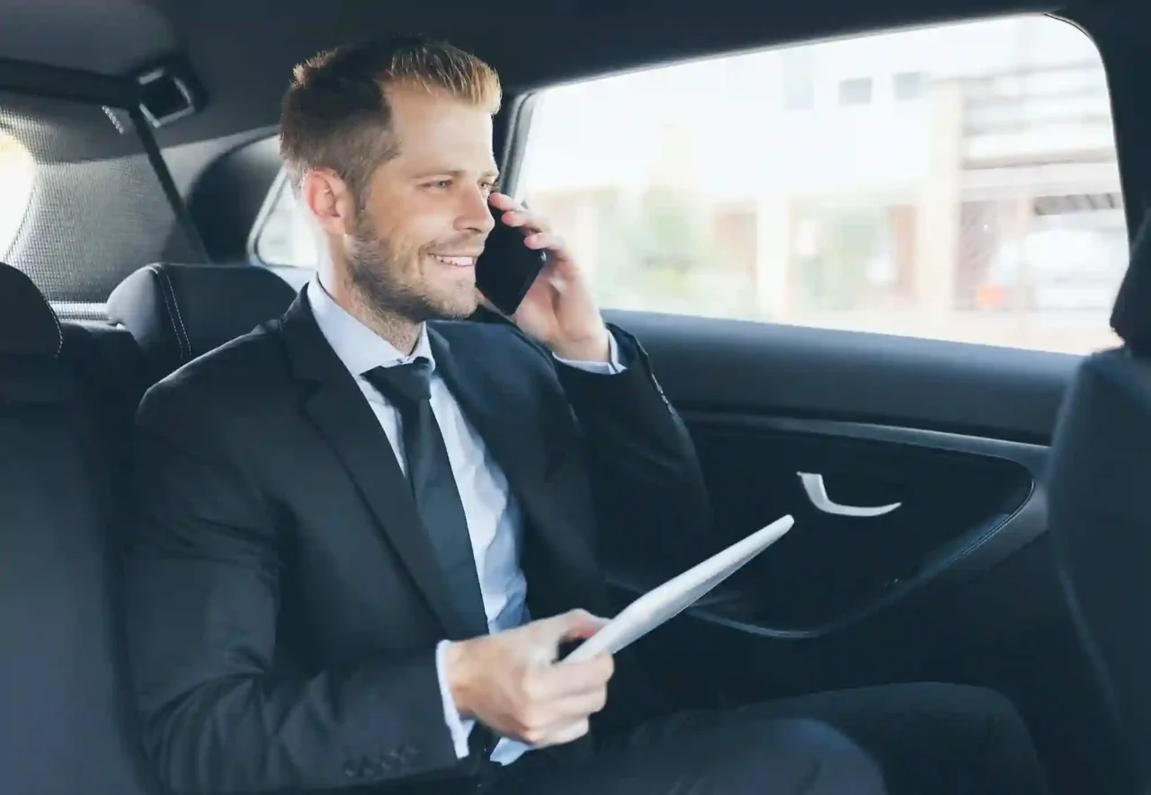 a man sitting in a car talking on a cell phone