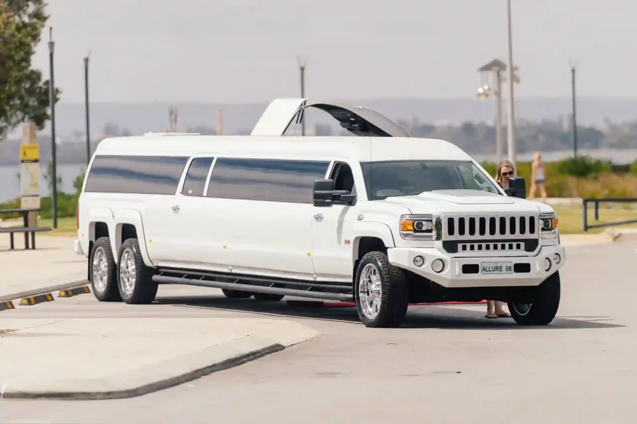 Jeep Limousine a white hummer is parked in a parking lot  