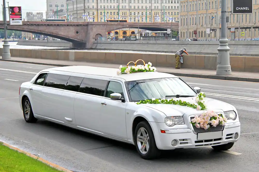 a white limousine with a flower arrangement on the back of it