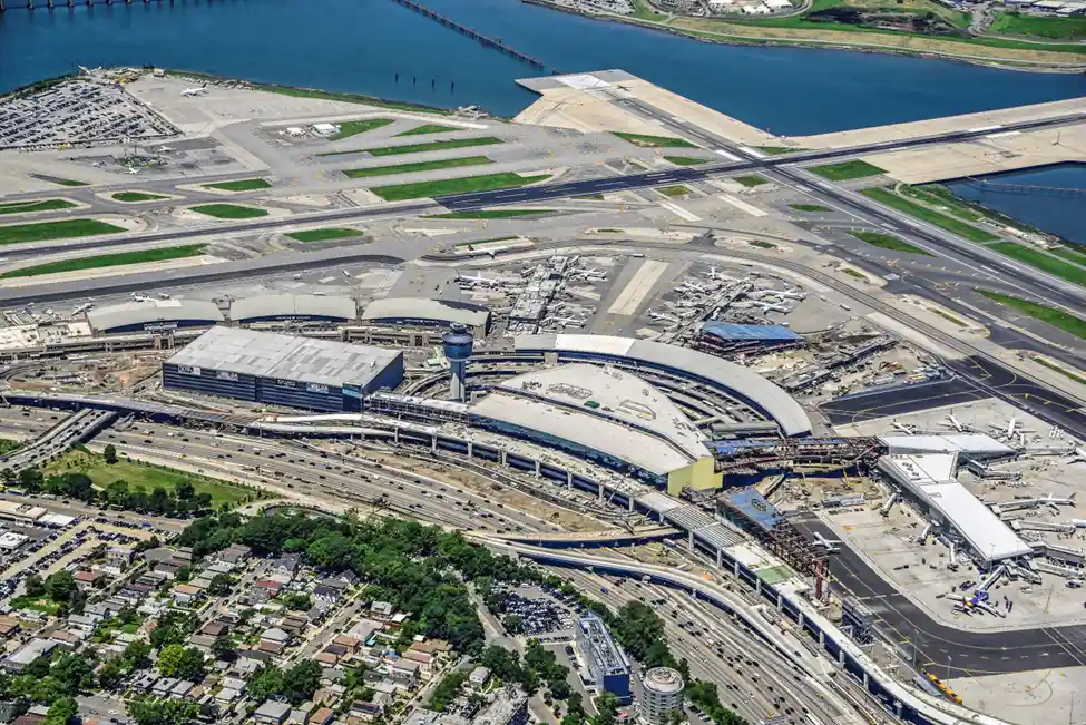 an aerial view of an airport with a body of water in the background